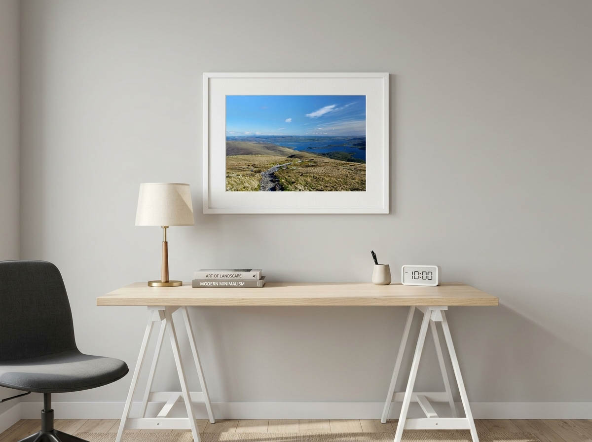 Looking out from the high ridge, a rugged stone path guides the eye downward into a vast, island-dotted expanse of water below. The composition balances the textured, weathered foreground of the uplands with the serene, luminous blue of the sky, offering a profound sense of openness and tranquility. Photographer: Stephane Loustalot